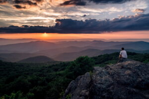 Hiker sitting on top of mountain.