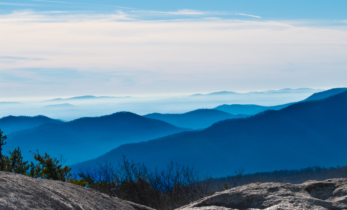 rolling mountains and a light haze seen from the top of a peak