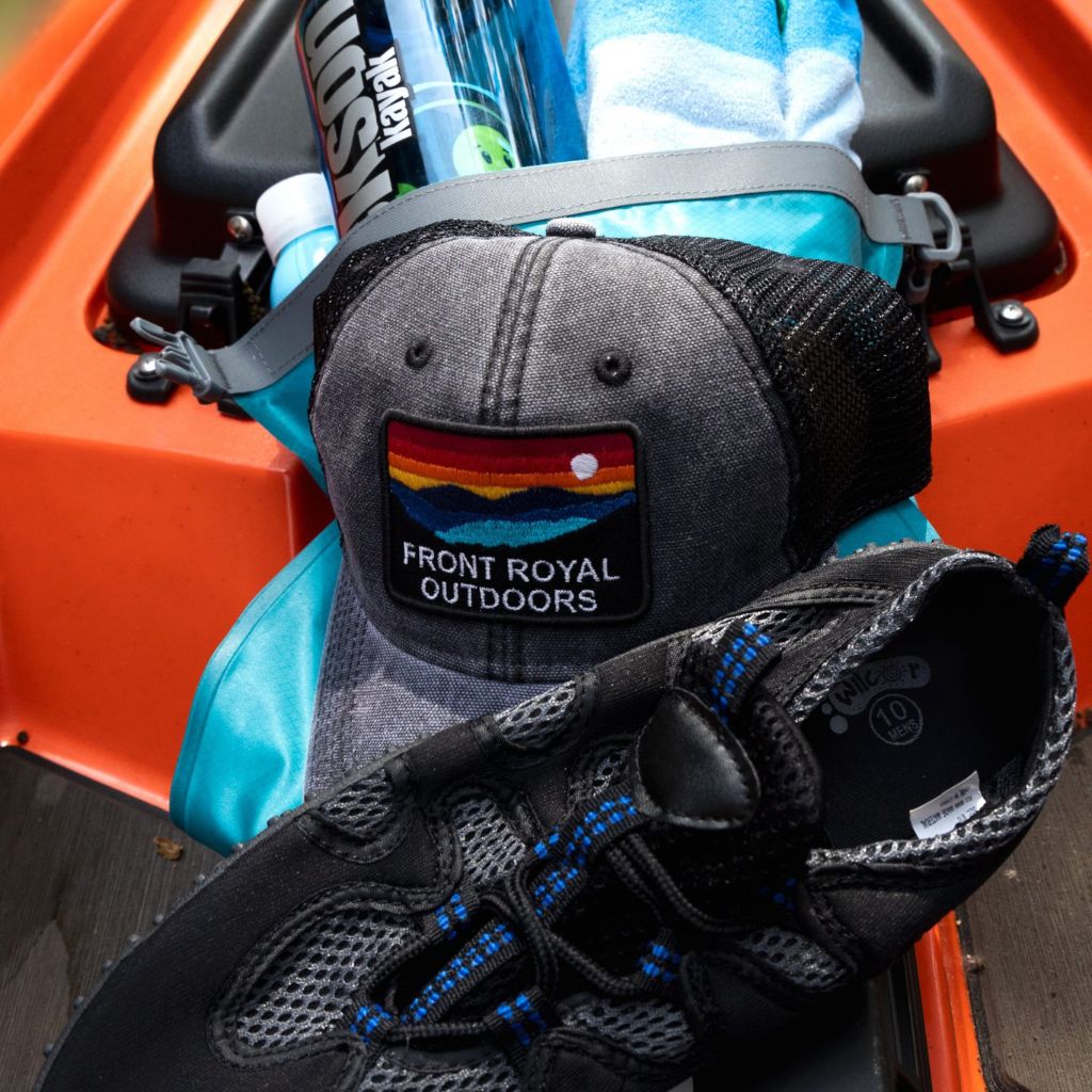 a hat, shoes, and water bottle on a kayak