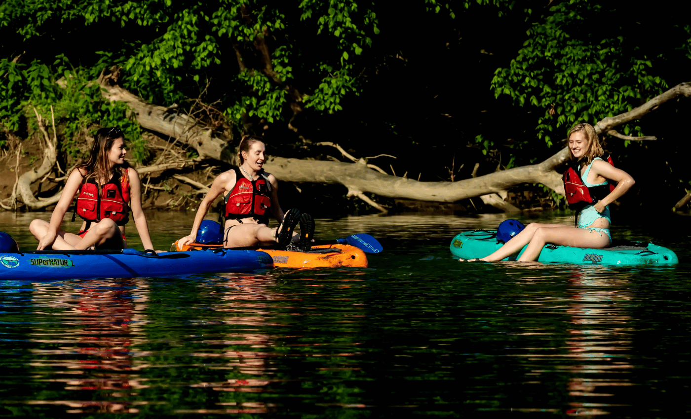 Girls having fun on shenandoah river while stand up paddleboarding. 