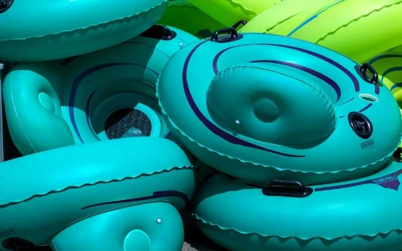 A pile of green river tubes